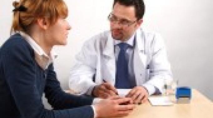 Doctor and young woman patient talking to each other.